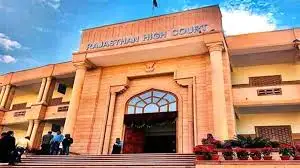 Rajasthan High Court entrance with people walking. Sandy facade, clear blue sky. Text