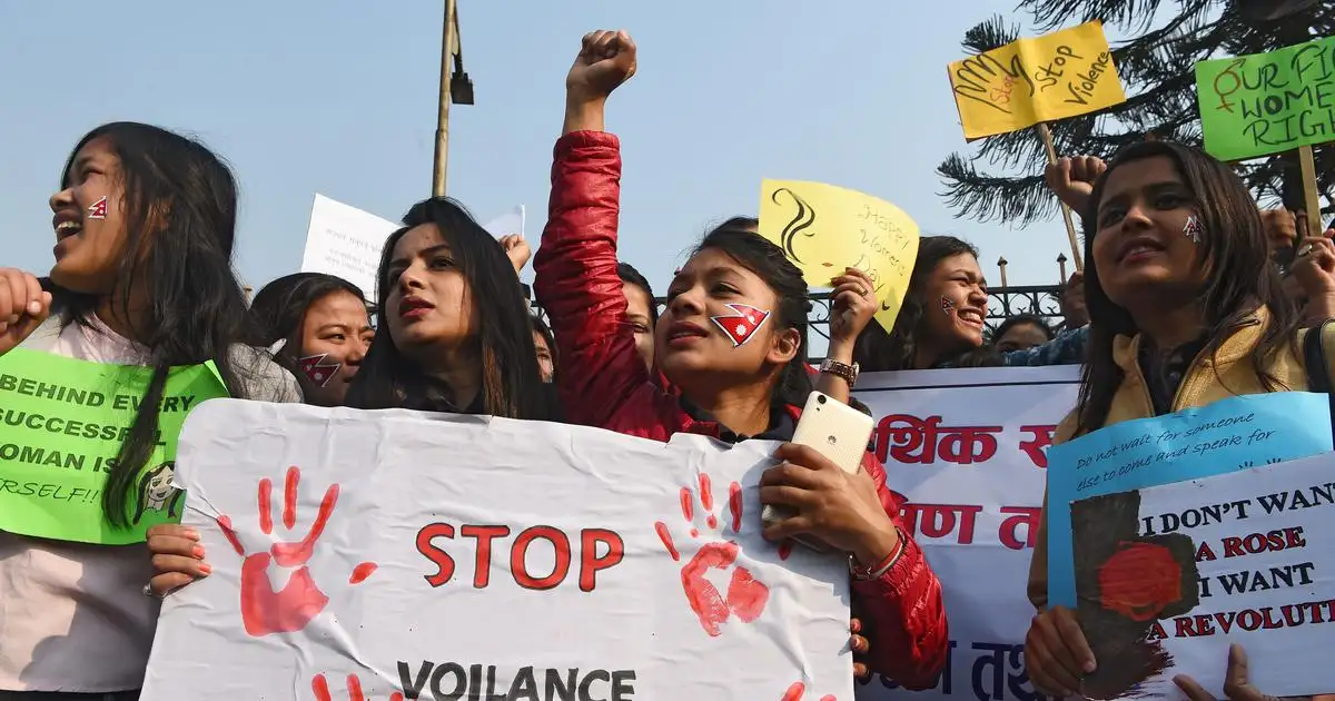 Women protest passionately, holding signs against violence. Red handprints, vibrant colors, and determined expressions fill the lively scene.